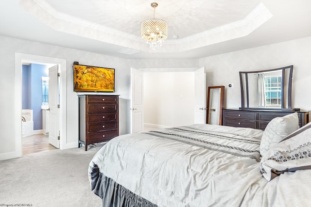 bedroom with ensuite bathroom, a raised ceiling, crown molding, a notable chandelier, and light colored carpet