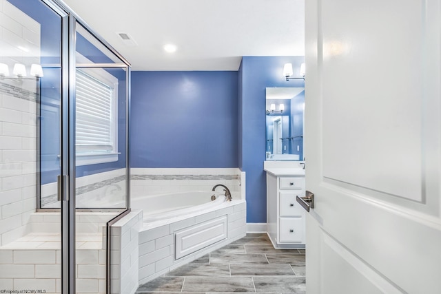 bathroom featuring vanity and tiled bath