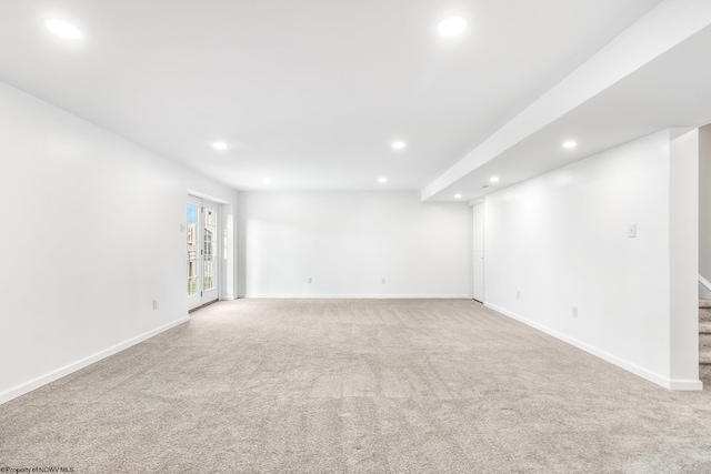 spare room featuring light carpet