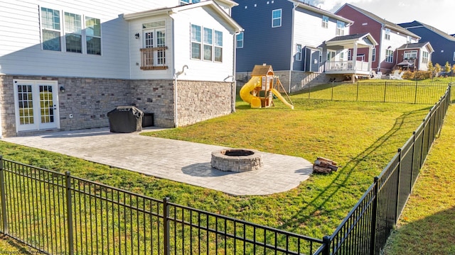 view of yard with an outdoor fire pit, a patio, and a playground