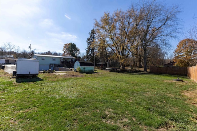 view of yard featuring a storage shed and a trampoline