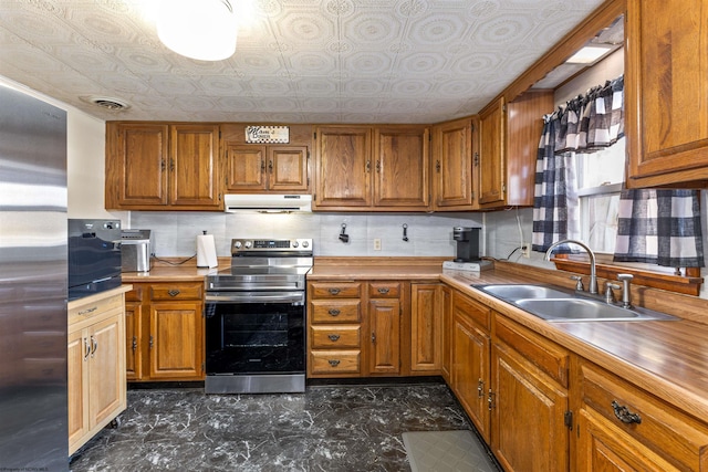 kitchen with sink, appliances with stainless steel finishes, and decorative backsplash