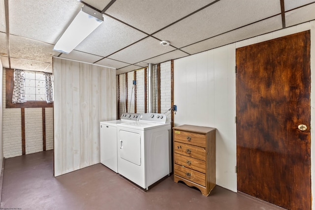 laundry area with independent washer and dryer and wooden walls