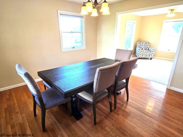 dining space with hardwood / wood-style flooring and a chandelier