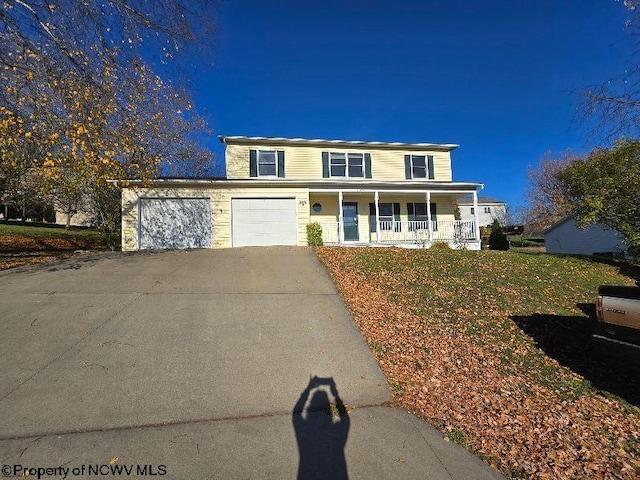 view of property featuring covered porch, a front yard, and a garage