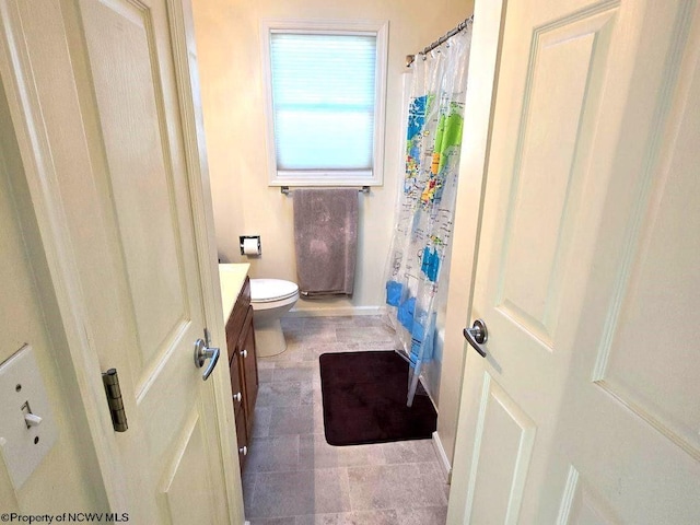 bathroom with a shower with shower curtain, vanity, and toilet