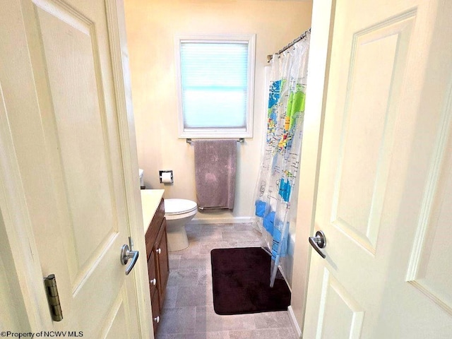 bathroom featuring curtained shower, vanity, and toilet