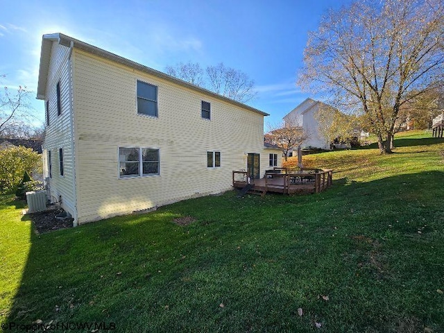 back of house with a lawn, a deck, and central AC