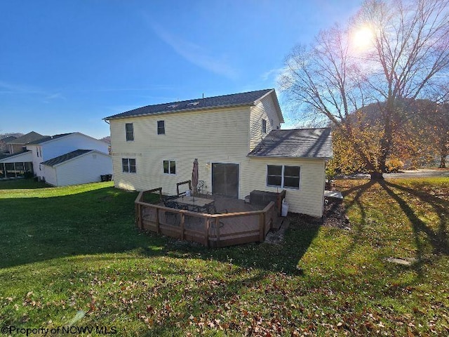 back of property featuring a lawn and a deck