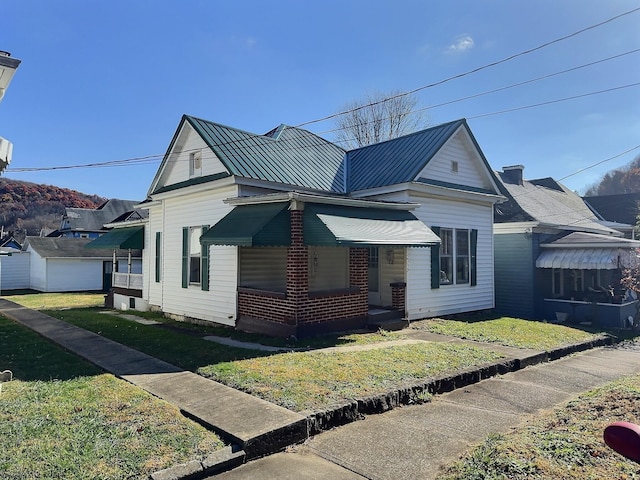 view of front of home with a front yard, a garage, and covered porch