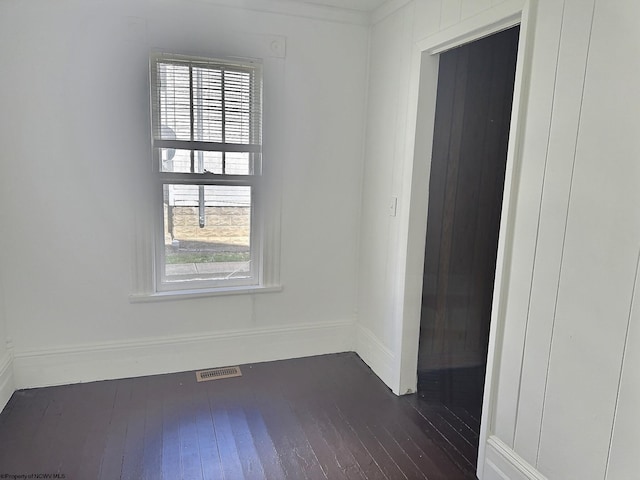 unfurnished room featuring a healthy amount of sunlight and dark hardwood / wood-style floors