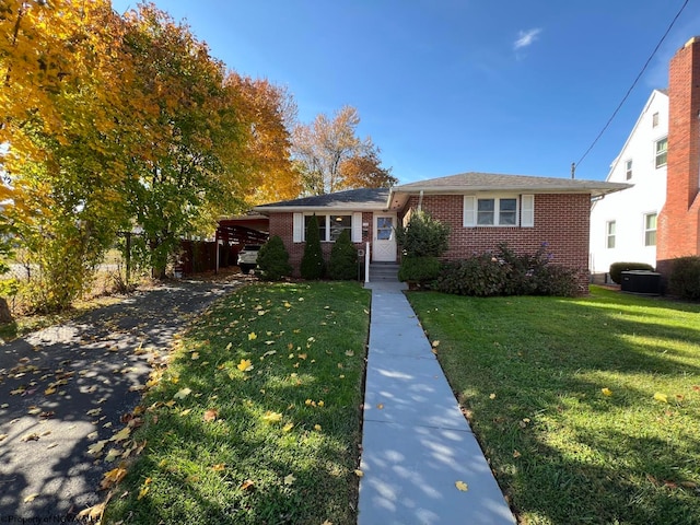 ranch-style house with a front yard and central AC unit