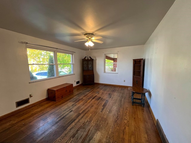 unfurnished living room with dark hardwood / wood-style flooring, ceiling fan, and plenty of natural light