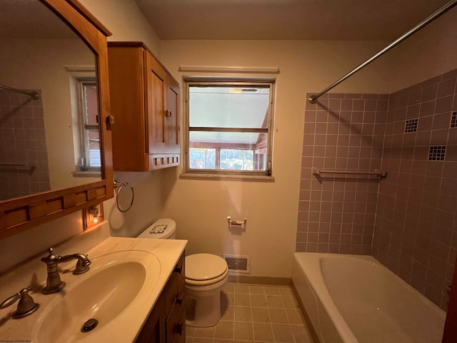 full bathroom featuring toilet, tiled shower / bath combo, vanity, and tile patterned flooring