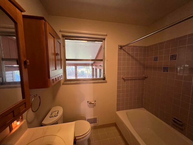 full bathroom with toilet, tiled shower / bath combo, vanity, and tile patterned flooring