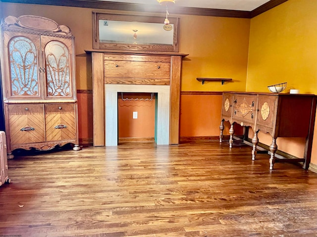 living area featuring ornamental molding, wood-type flooring, and radiator heating unit