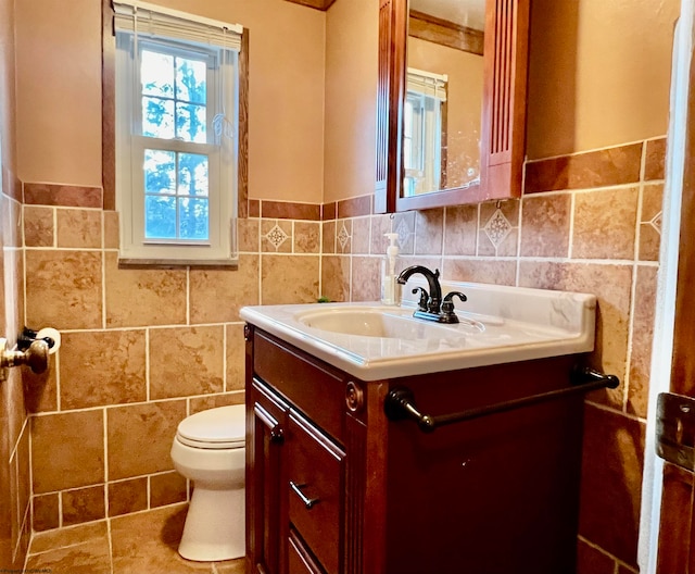 bathroom with tile walls, vanity, and toilet