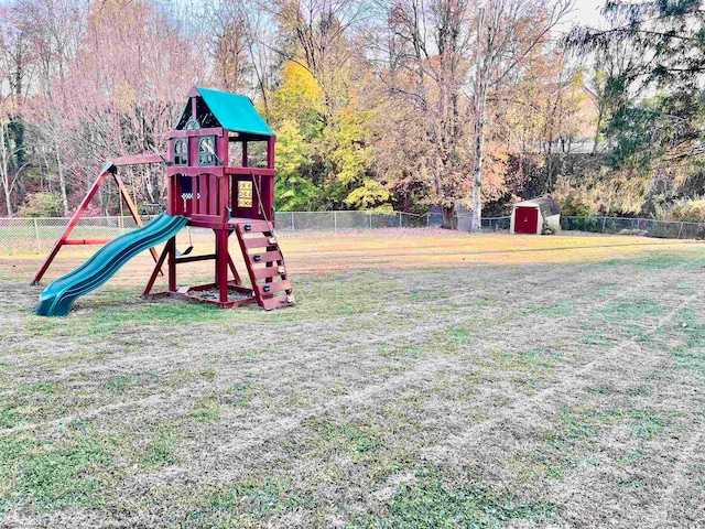 view of jungle gym featuring a yard and a shed