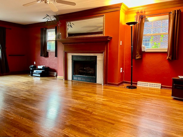 unfurnished living room featuring ornamental molding, hardwood / wood-style flooring, and ceiling fan