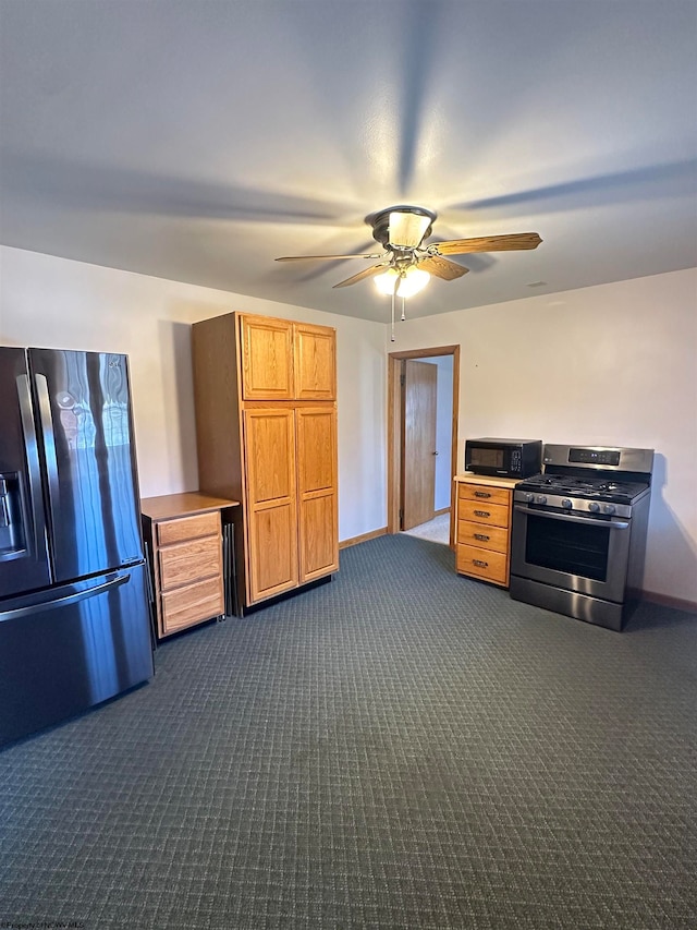 kitchen with appliances with stainless steel finishes, dark carpet, and ceiling fan