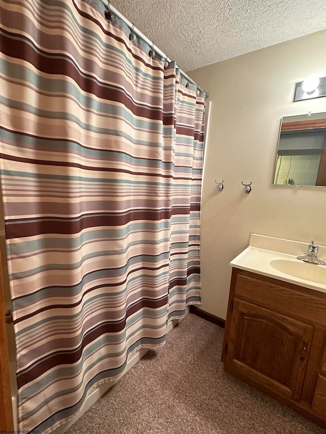 bathroom featuring vanity, a textured ceiling, and curtained shower