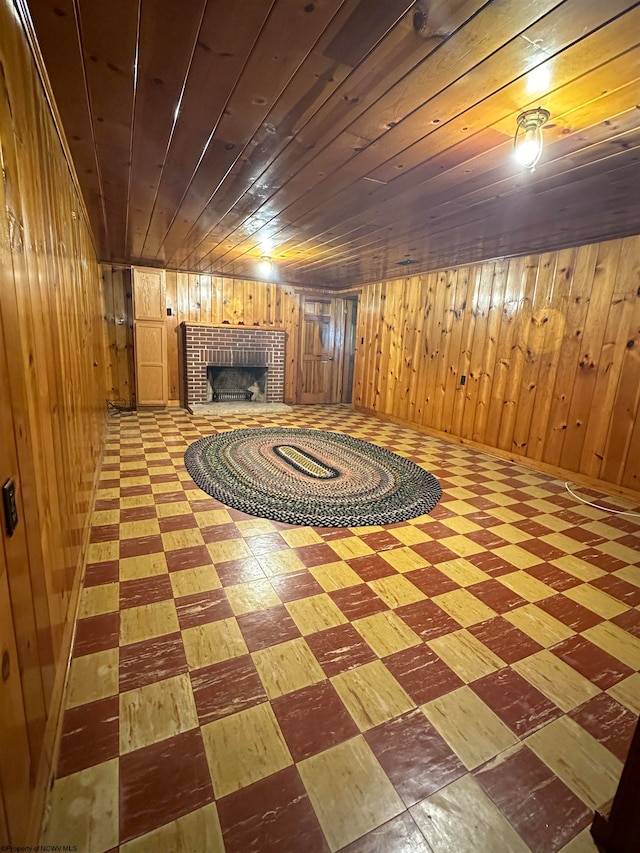 basement featuring wood ceiling, wooden walls, and a fireplace