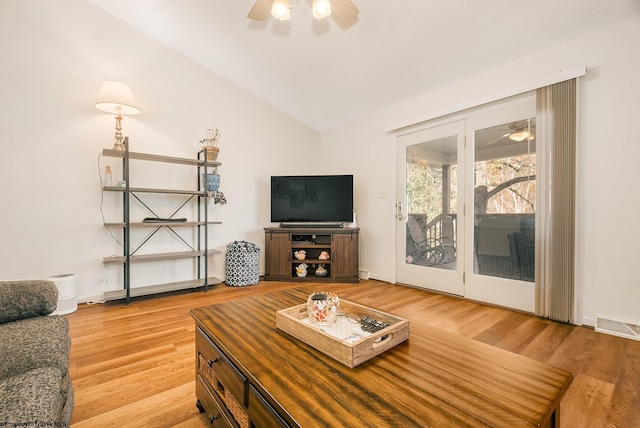 living room featuring light wood-type flooring, ceiling fan, and vaulted ceiling