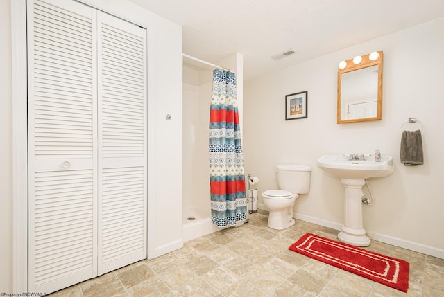 bathroom with toilet and curtained shower