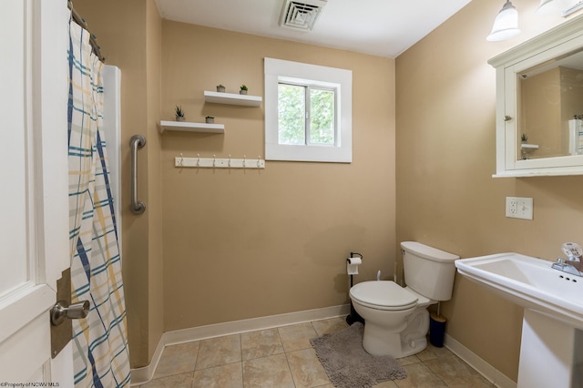 bathroom featuring a shower with shower curtain, tile patterned floors, and toilet