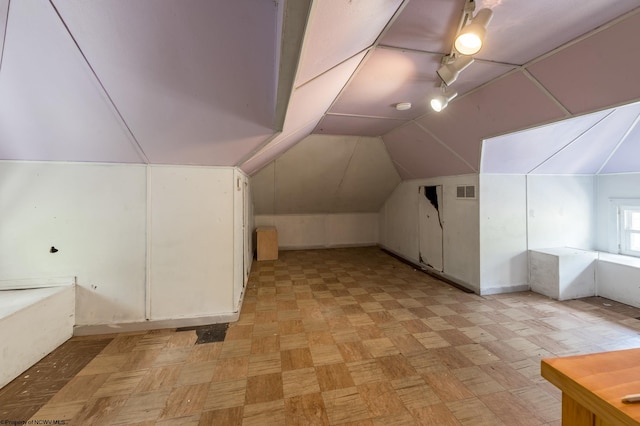 bonus room with light parquet flooring and lofted ceiling