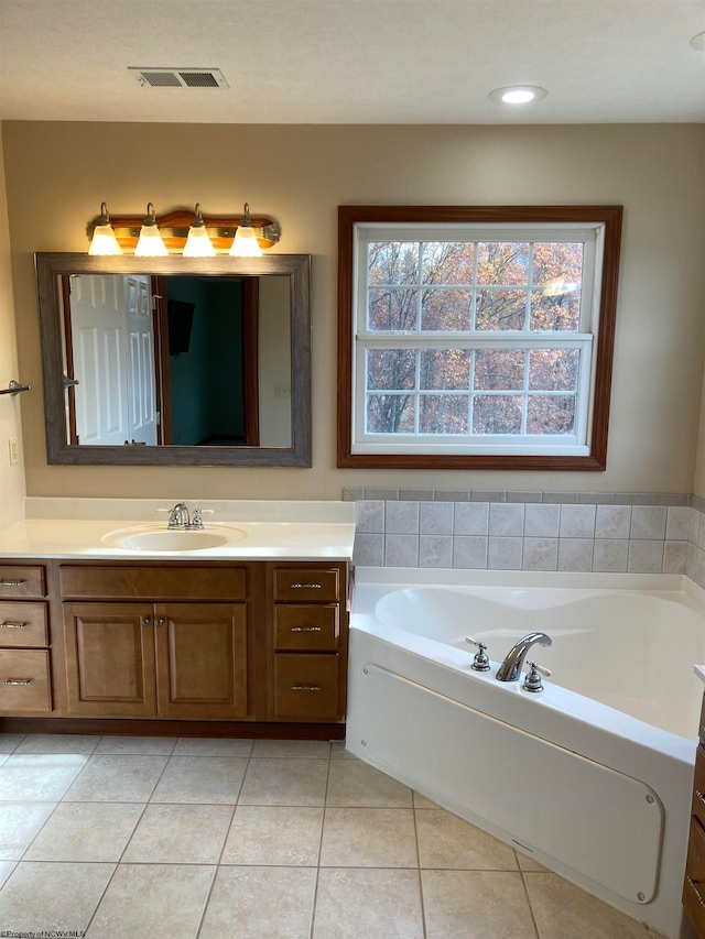 bathroom with a bathtub, vanity, and tile patterned flooring