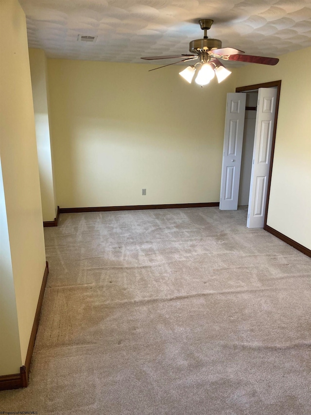 unfurnished room with ceiling fan and light colored carpet