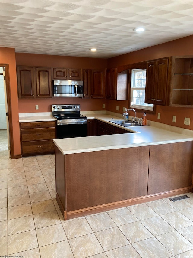 kitchen with stainless steel appliances, light tile patterned floors, sink, and kitchen peninsula