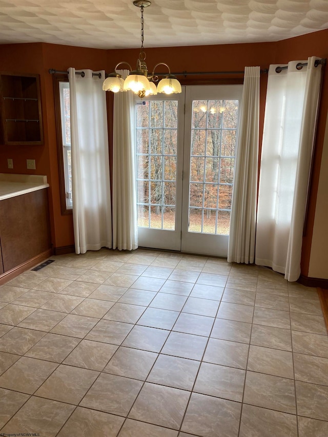 unfurnished dining area featuring a chandelier and light tile patterned floors