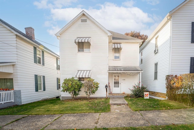 view of property with cooling unit and a front lawn