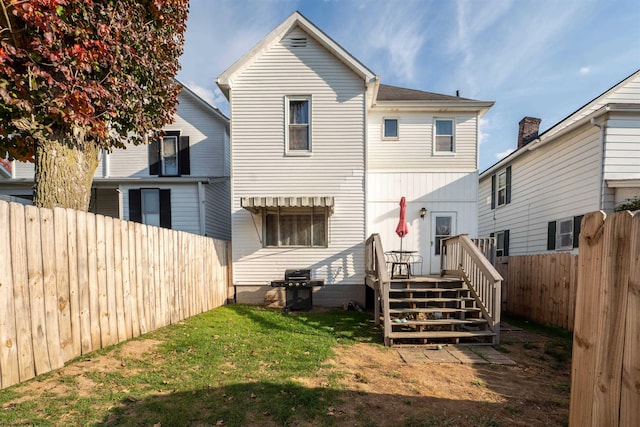 rear view of property featuring a lawn