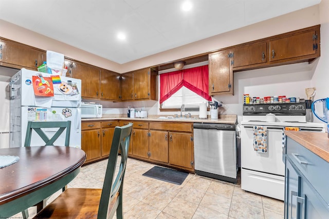 kitchen with sink, white appliances, and light tile patterned floors