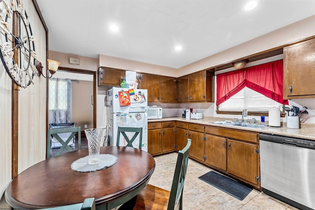 kitchen featuring light tile patterned floors, white appliances, a healthy amount of sunlight, and sink