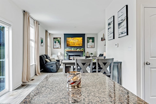 dining space featuring a fireplace and light wood-type flooring