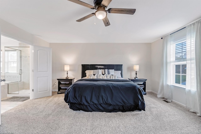 bedroom featuring ceiling fan, ensuite bath, and light carpet