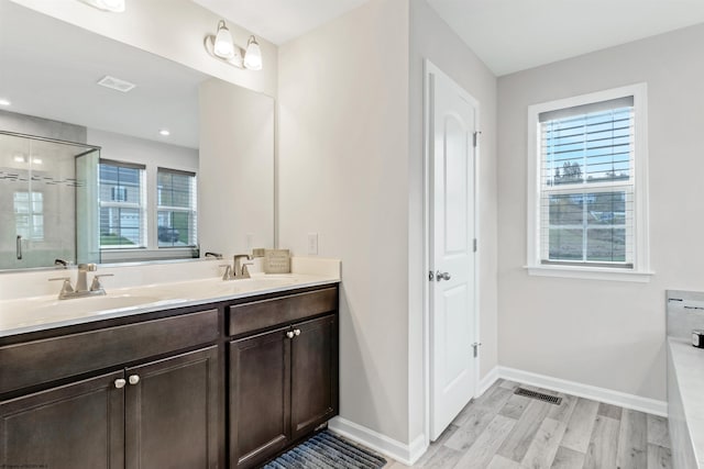 bathroom featuring vanity, hardwood / wood-style flooring, and a shower with door