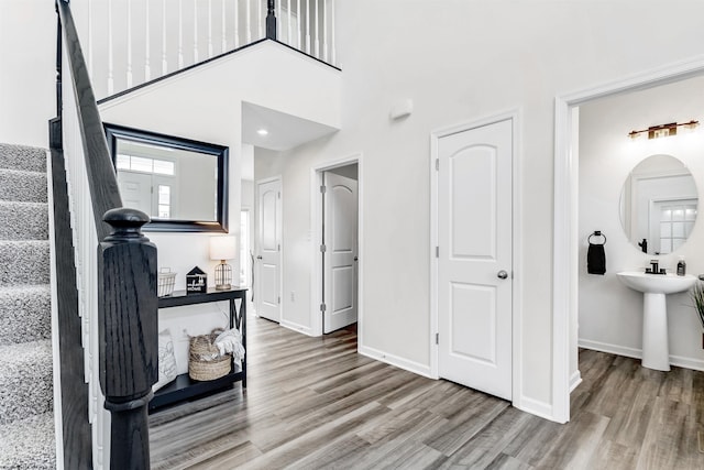 hallway with hardwood / wood-style flooring and a high ceiling