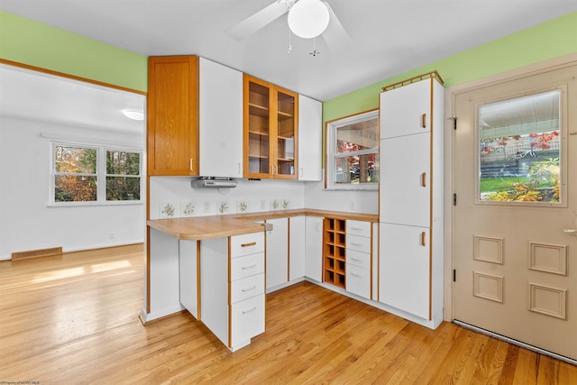 kitchen featuring white cabinetry, light wood-type flooring, and ceiling fan