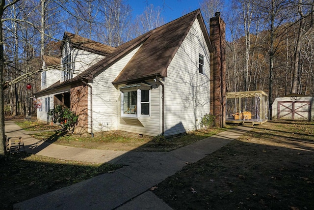 view of property exterior with a storage unit