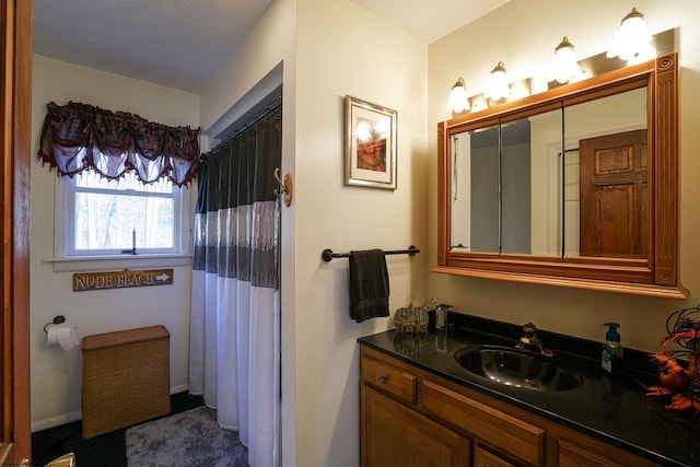 bathroom featuring a shower with curtain, vanity, and a textured ceiling