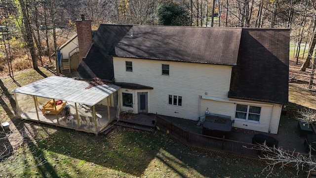 back of property featuring a lawn and a wooden deck