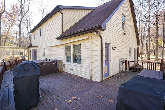 deck with a hot tub and area for grilling