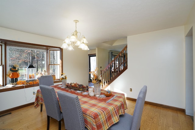 dining area featuring a chandelier, plenty of natural light, and light hardwood / wood-style flooring