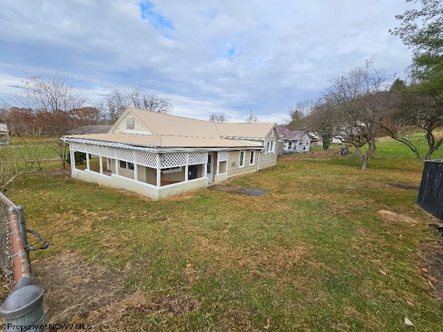 back of house with a sunroom and a yard