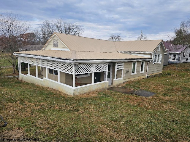 back of house featuring a sunroom and a yard